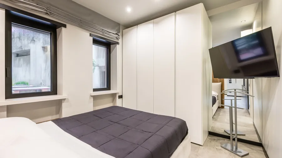 Zona notte Santopaolo 5 con letto matrimoniale, armadiatura bianca e smart TV