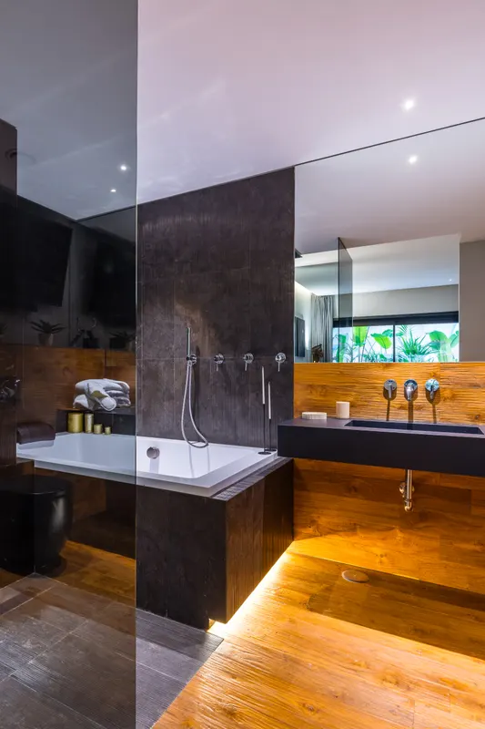 Bagno en suite di Santopaolo 1 con vasca, pietra scura e parete in legno