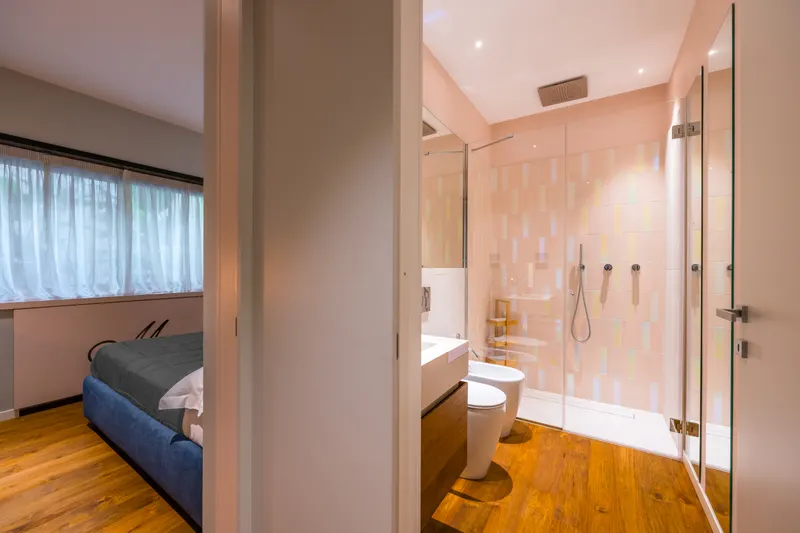 Secondo bagno di Santopaolo 1 visto dal corridoio, doccia in vetro e parquet