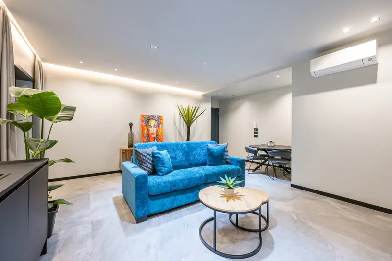 Salone di Santopaolo 4 con divano blu, pianta e quadro