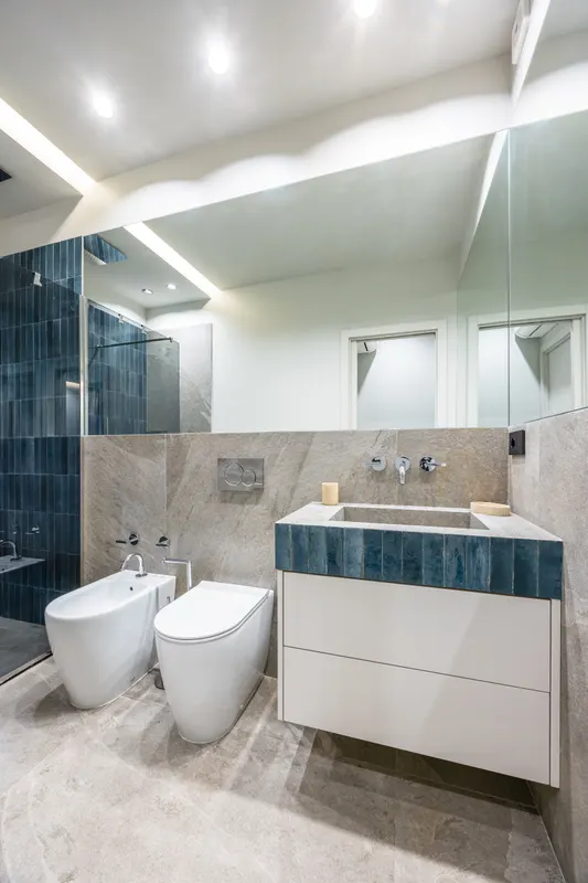 Bagno di Santopaolo 4 con piastrelle blu, lavabo in pietra e sanitari
